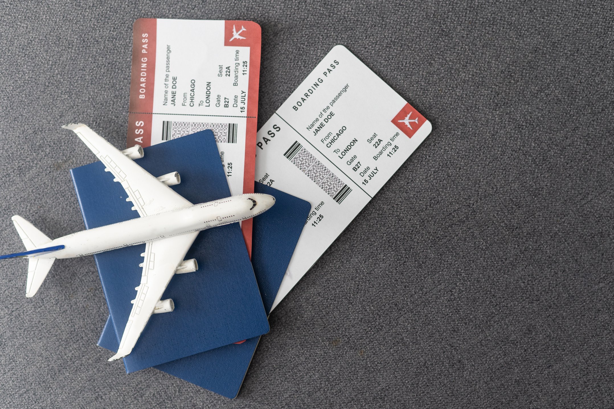 Plane tickets, passports and toy plane on table